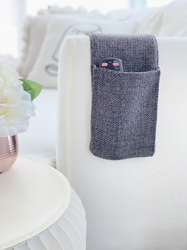 the charcoal remote control caddy on a couch arm