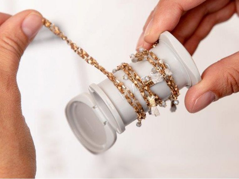 white barrel with a lid on top and a necklace wrapped around it