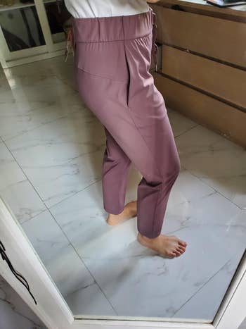 Person standing in mirror reflection showing fit of casual drawstring pants