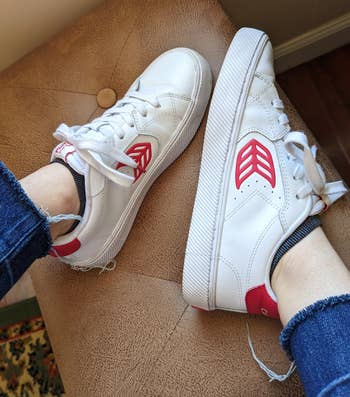 BuzzFeed editor wearing the same sneakers with the logo on the side and heel tab in red 