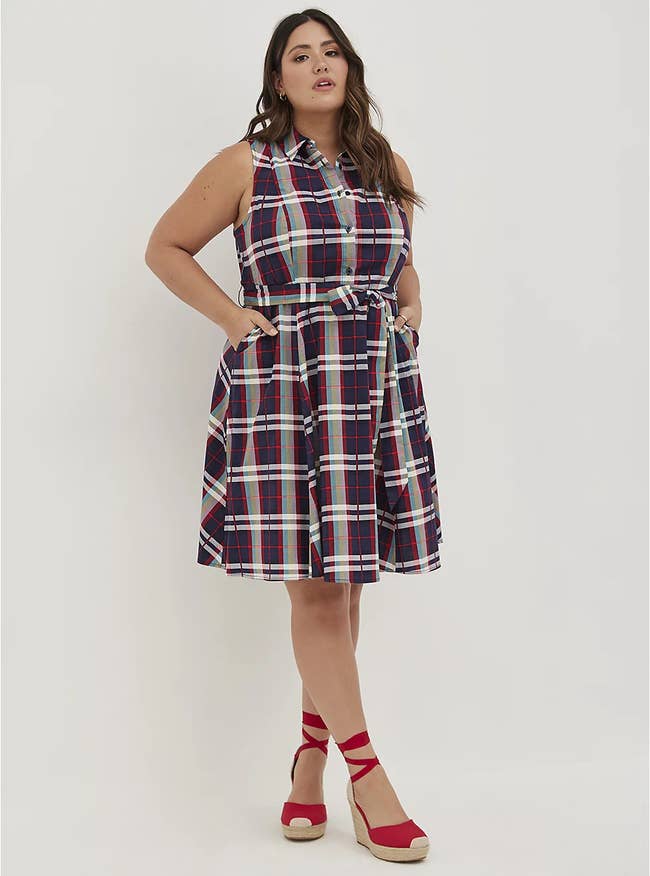 model wears sleeveless plaid collared shirt dress with red wedges