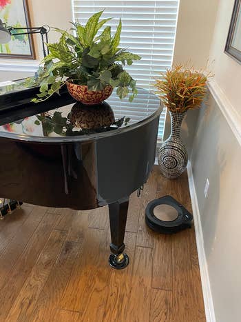Reviewer's home with roomba smart vac underneath the baby grand piano