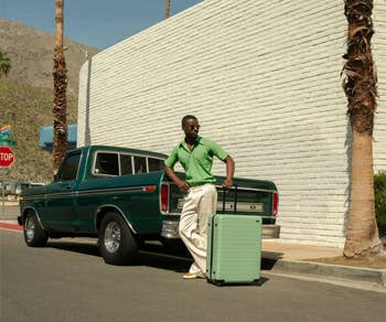 model posing with the light green suitcase