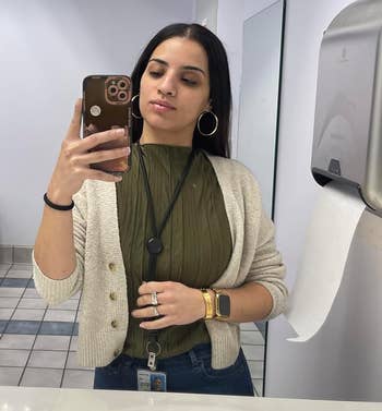Person taking selfie wearing a cardigan over the green ruffled tank