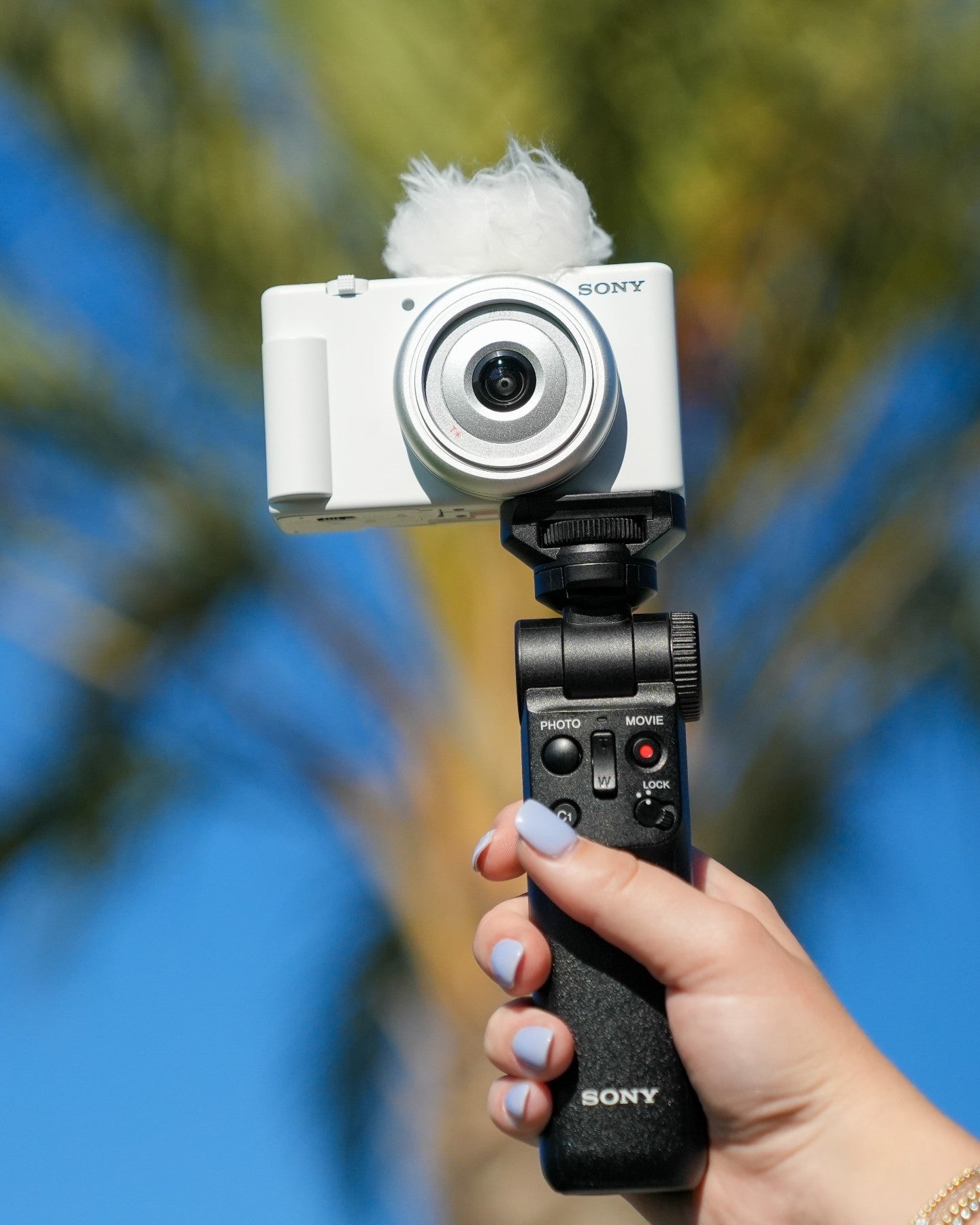someone holding the camera on a tripod in white