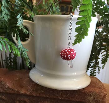 A white mug with a mushroom dangling off the side