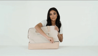 gif of shay mitchell opening the shoe compartment at bottom of bag
