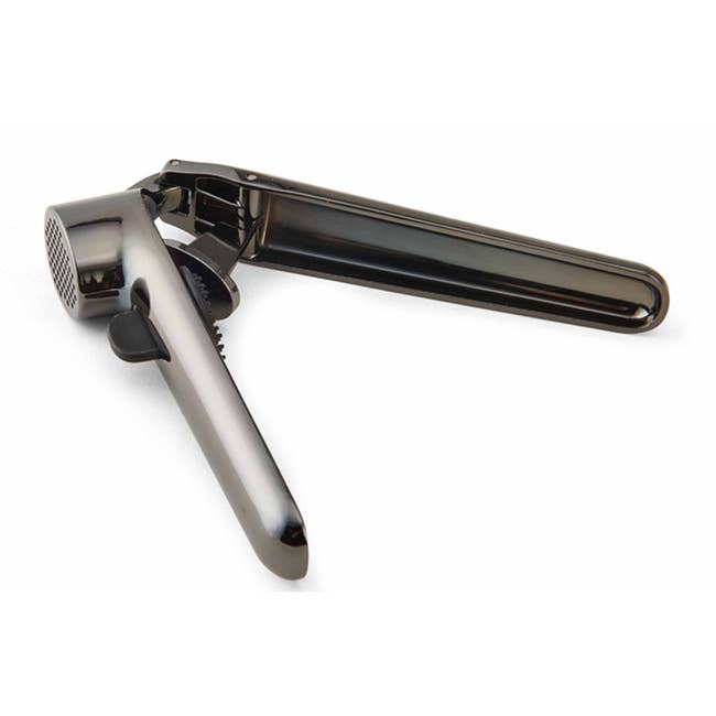 Metal ail property with ergonomic handles and a perforated enclosure for crushing cloves