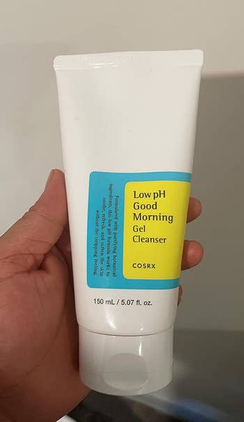 A reviewer holding the cleanser