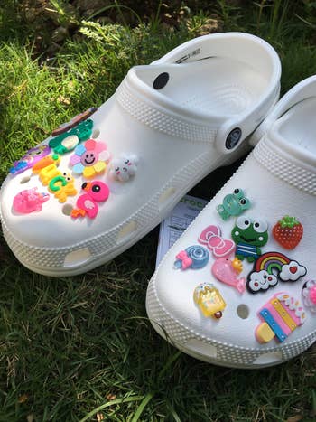 White clogs connected  writer  decorated with colorful, playful charms similar  animals and nutrient  items