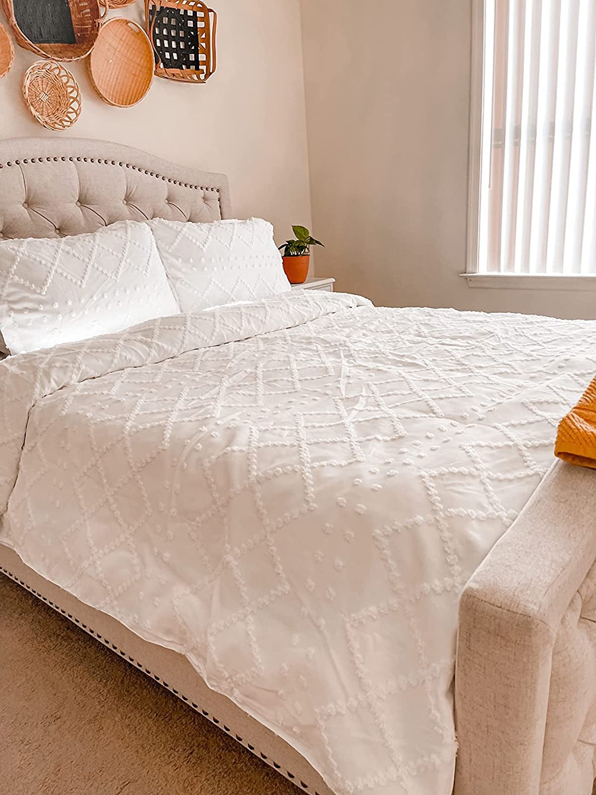 reviewer photo of the white duvet cover with a geometric dimensional diamond and dot pattern on it
