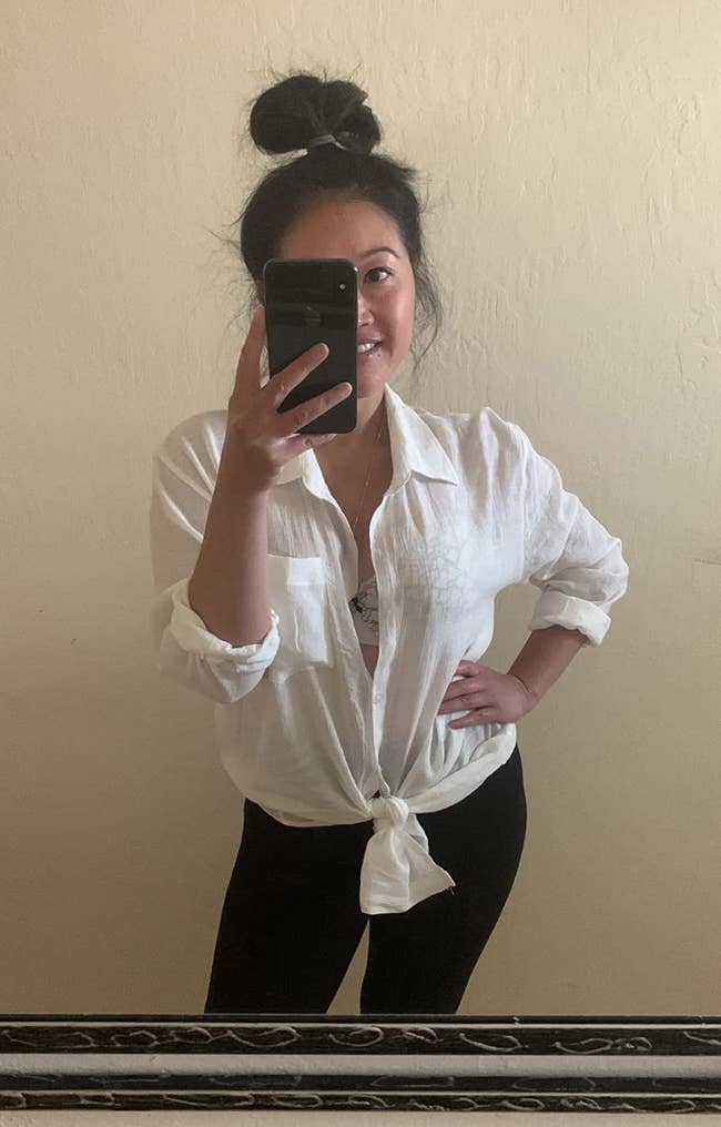 reviewer posing in tied up white button down blouse