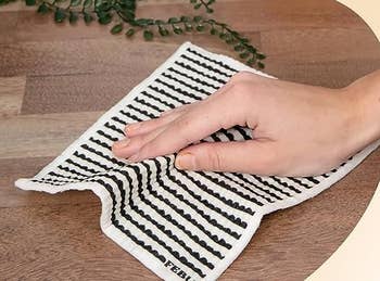 model's hand using the Swedish dishcloth to clean surface