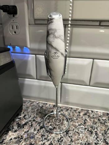 Reviewer image of white marble handheld frother on its stand