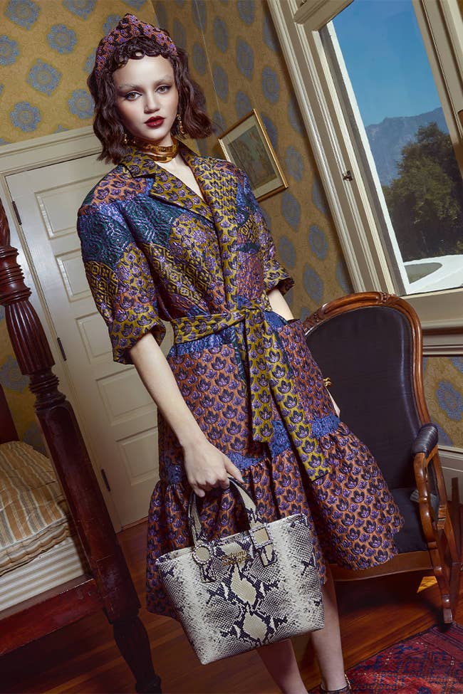 model in elbow sleeve knee-length collared coat dress in mixed orange blue yellow and purple brocade
