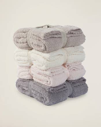 a stack of blankets in four different colors