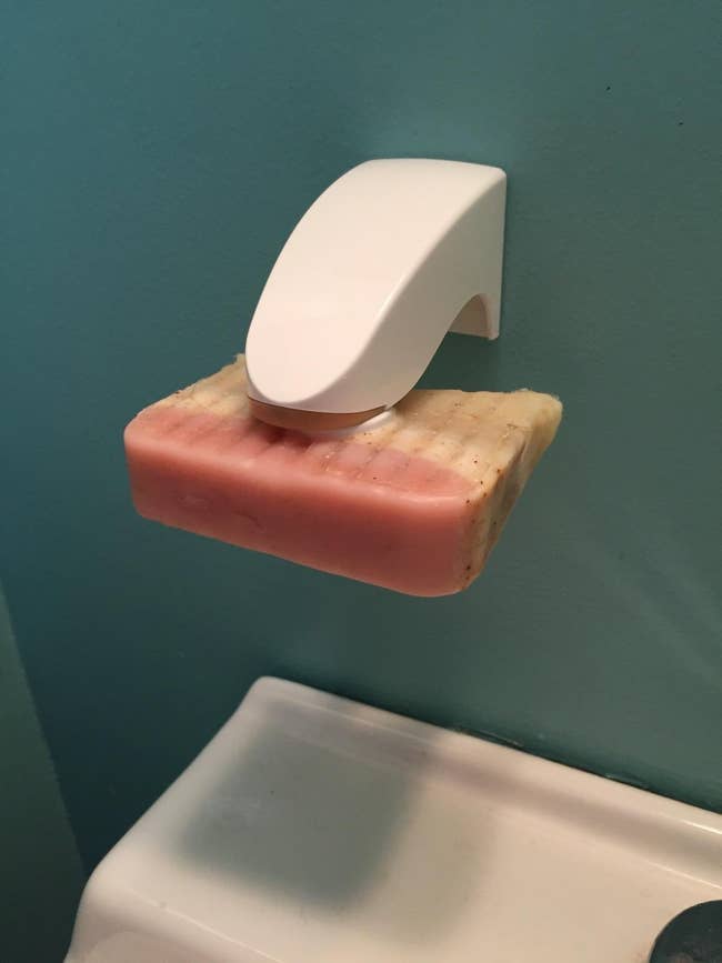 a pink and yellow bar of soap suspended from the holder