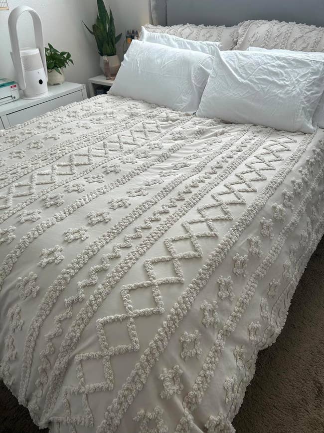 White textured bedding set with floral patterns on a bed in a room, ideal for a cozy bedroom upgrade