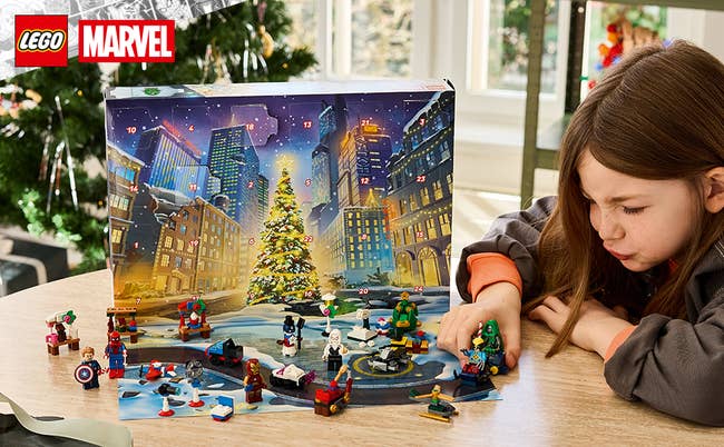 Child playing with a LEGO Marvel Advent calendar set, featuring superhero-themed mini-figures and a festive metropolis  country   background