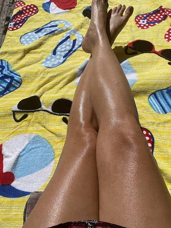 reviewer's legs looking shimmery on a beach towel