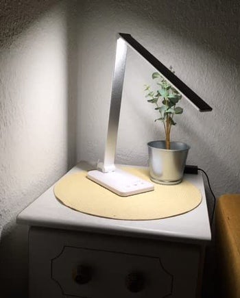 a sleek desk lamp lighting up a table