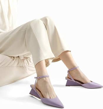 a model wearing the wedge sandals in lilac 
