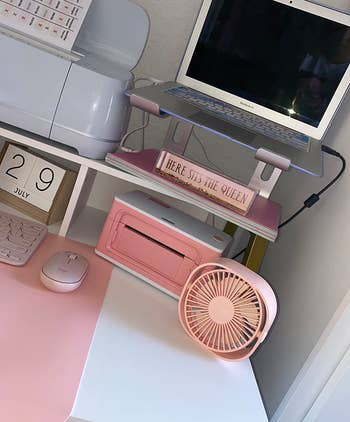 A reviewer shows the pink fan on their desk