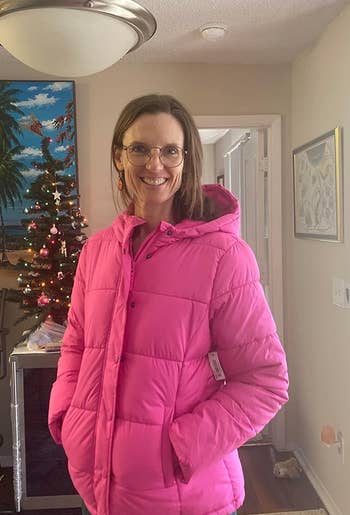 a reviewer wearing the coat in pink 