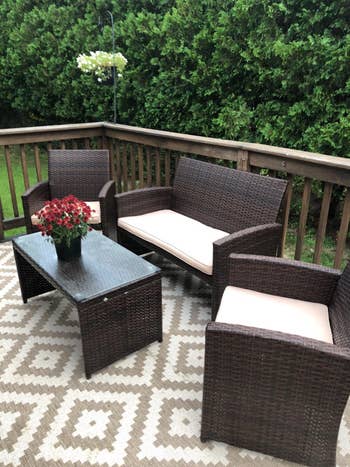 The brown patio furniture with cream cushions on a deck