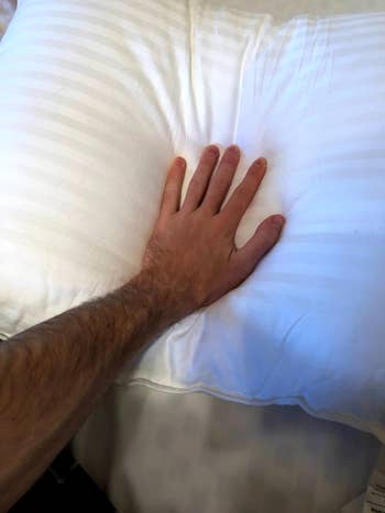 hand pressing down on pillow