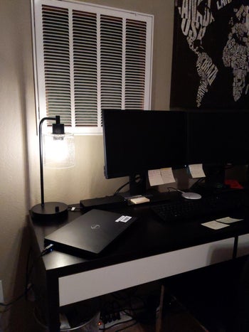 reviewer photo of an industrial-style black lamp lighting up their dark desk