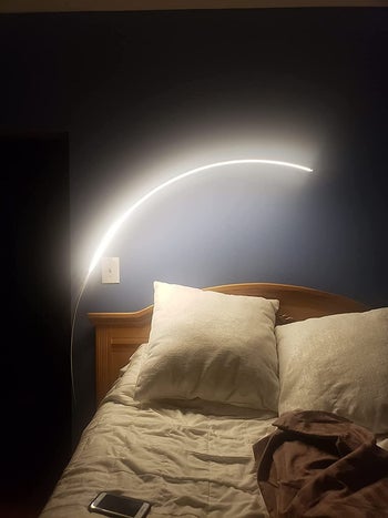 Reviewer image of product next to bed illuminating room