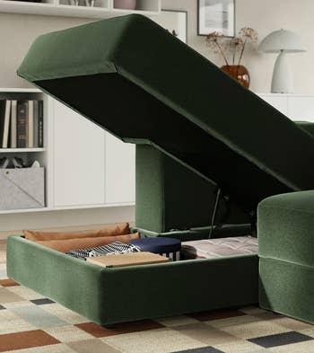 Ottoman-style sofa with retention compartment open, showing neatly organized blankets and books, acceptable successful a modern surviving country with shelves