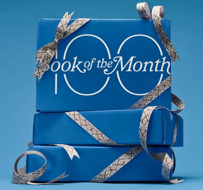 three stacked boxes wrapped successful bows with Book of the Month and 100 connected 1 of them