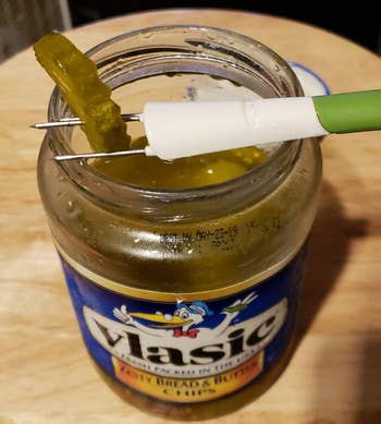 reviewer photo of the snack fork stabbing a pickle in a jar