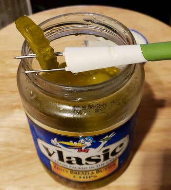 reviewer photo of the snack fork stabbing a pickle in a jar