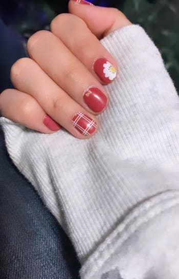 nails with the wraps applied in red designs with plaid, a little bow, and a flower