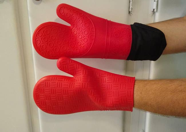 a reviewer wearing the oven mitts in red 