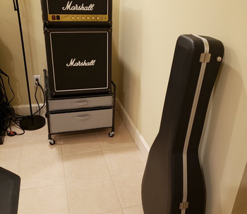 a marshall amp mini fridge with a guitar case next to it
