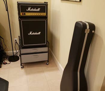 a marshall amp mini fridge with a guitar case next to it