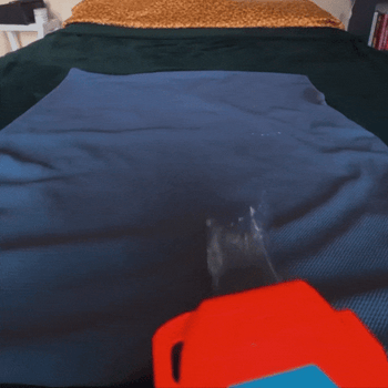 Water being sprayed on blanket to show water-resistance