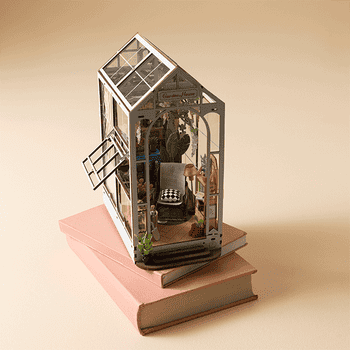 Miniature greenhouse exemplary connected 2 books, showcasing elaborate interior decor including plants and furniture, cleanable for location decor enthusiasts