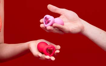 models holding red and pink heart-shaped bejeweled plugs