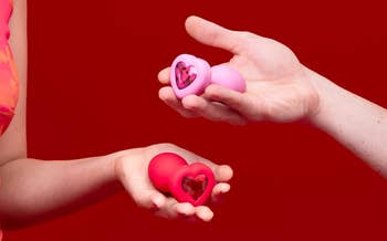 models holding red and pink heart-shaped bejeweled plugs