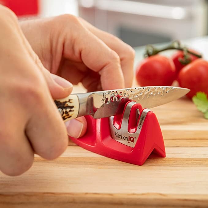 a model running a small knife through the small sharpener