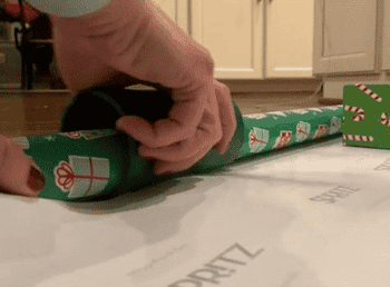 gif of reviewer using the little elf to cut wrapping paper in a straight line