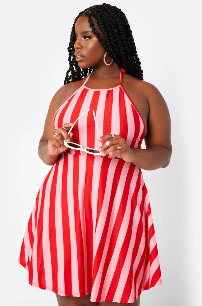 model in short red and pink stripe dress