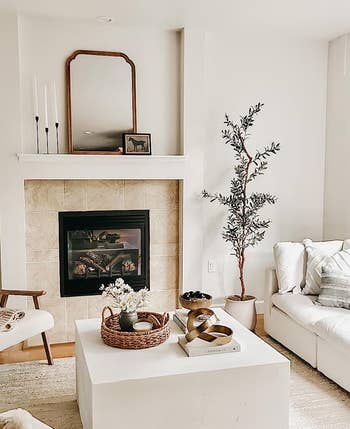 Modern living room with a fireplace, sofa, chairs, and decor, reflecting a cozy and minimalist style for home inspiration
