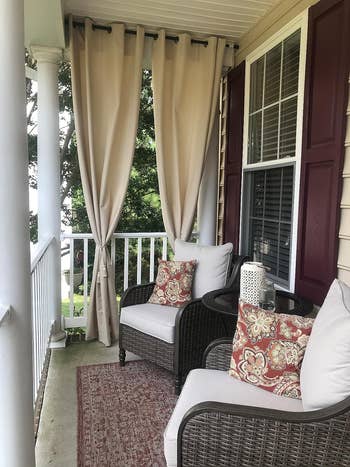 A reviewers curtains in beige covering one side of their porch