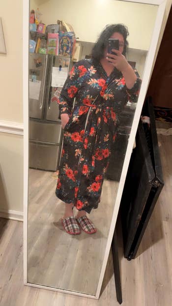 Person wearing a floral robe and plaid slippers, taking a reflector  selfie successful  a kitchen, perchance  highlighting comfy  loungewear for shopping